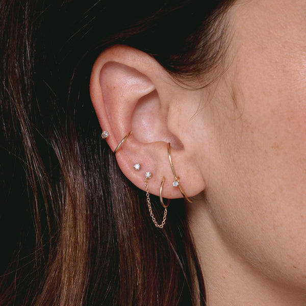 close up woman's ear wearing Zoë Chicco 14k Gold Single Prong Diamond Double Ear Cuff