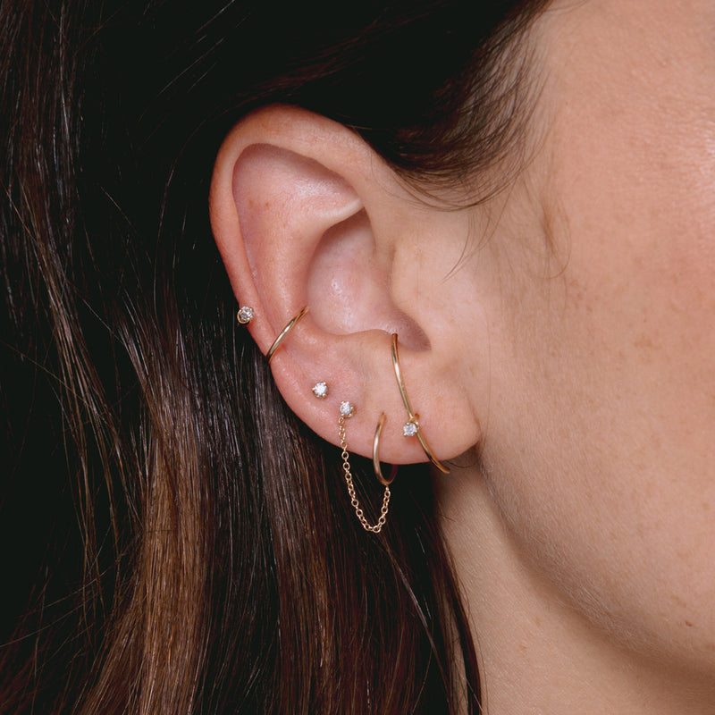 close up woman's ear wearing Zoë Chicco 14k Gold Single Prong Diamond Double Ear Cuff