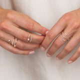 close up of woman's hands in front an ivory silk background wearing Zoë Chicco 14kt Gold Double Wrap Ring with Pave Diamonds