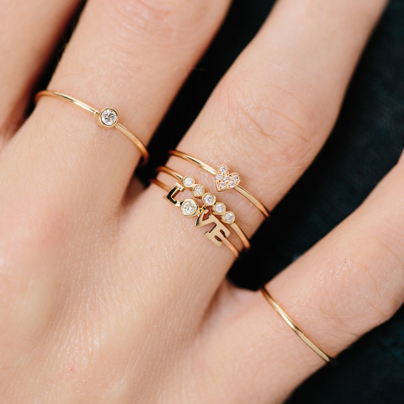 woman's hand wearing Zoë Chicco 14kt Gold Itty Bitty Pavé Diamond Heart Ring