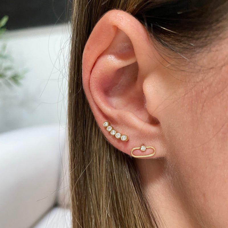 woman's ear wearing Zoë Chicco 14kt Gold 5 Diamond Bezel Curved Bar Stud Earrings