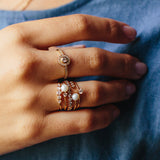 close up of woman's hand wearing Zoe Chicco 14kt Gold Pearl & 3 Diamond Bezel Open Ring