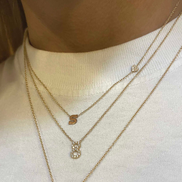 woman in white t-shirt wearing Zoë Chicco 14k Gold Pavé Diamond Number Necklace layered with a Initial and Pave Diamond Heart Necklace