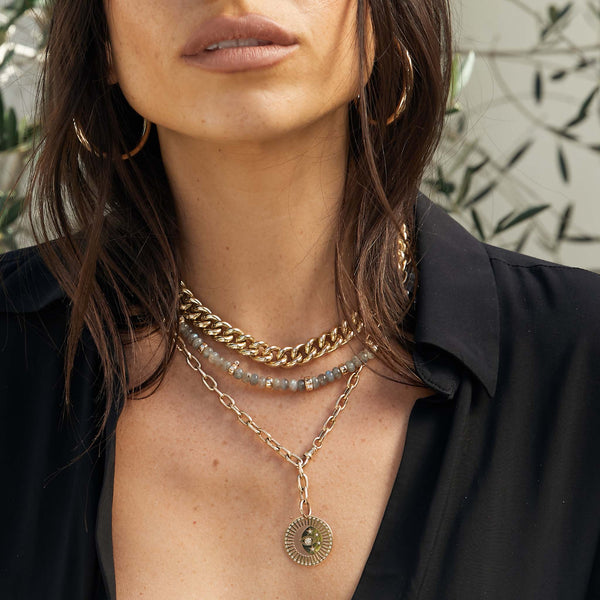 woman in black top wearing a Zoë Chicco 14k Gold & Labradorite Rondelle Bead Necklace with 5 Prong Diamonds with a leaf background