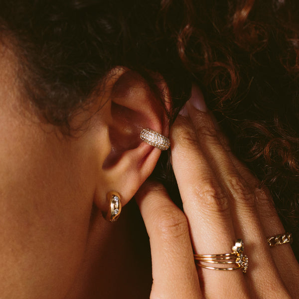 woman's ear wearing Zoë Chicco 14kt Gold Pavé Diamond Wide Chubby Ear Cuff with a chubby huggie hoop