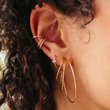 close up of woman's ear wearing a Zoë Chicco 14k Gold Triple Wire Large Hoop Earring