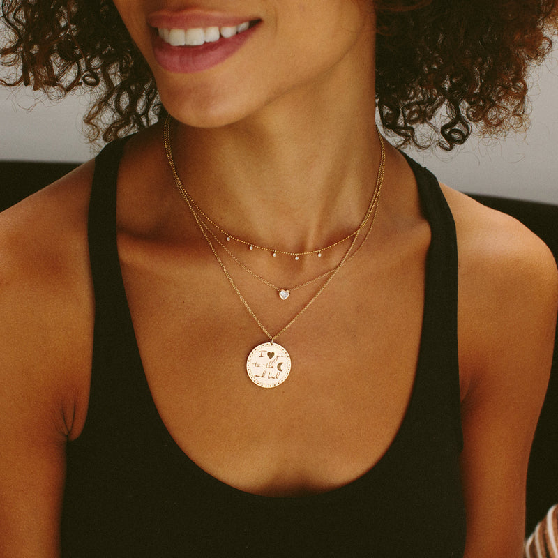 woman in black top wearing Zoë Chicco 14kt Gold Floating Heart Shaped Diamond Necklace