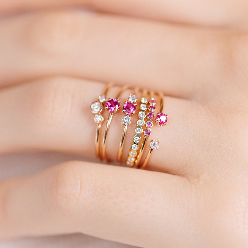close up of woman's finger wearing a stack of multiple Zoe Chicco 14k Gold, Diamond, and Ruby rings