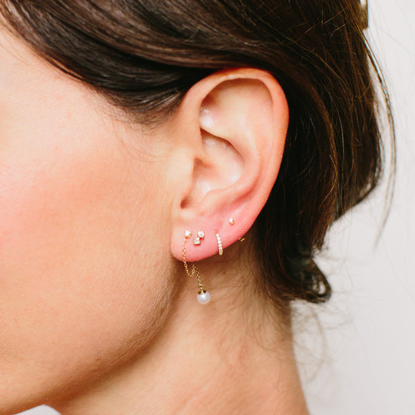 woman's ear wearing a Zoë Chicco 14k Gold Prong Diamond Chain Huggie Earring with Pearl Drop