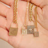 Four Zoe Chicco 14kt Gold Padlock Chain Necklaces laying inside the palm of a hand