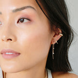 close up of left side of woman's face wearing Zoë Chicco 14kt Gold Graduating 3 Prong Diamond Wire Hook Earring in her ear
