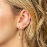 close up of woman's ear wearing 14k Gold Medium Thin Hammered Hoop Earring looped through two earring holes