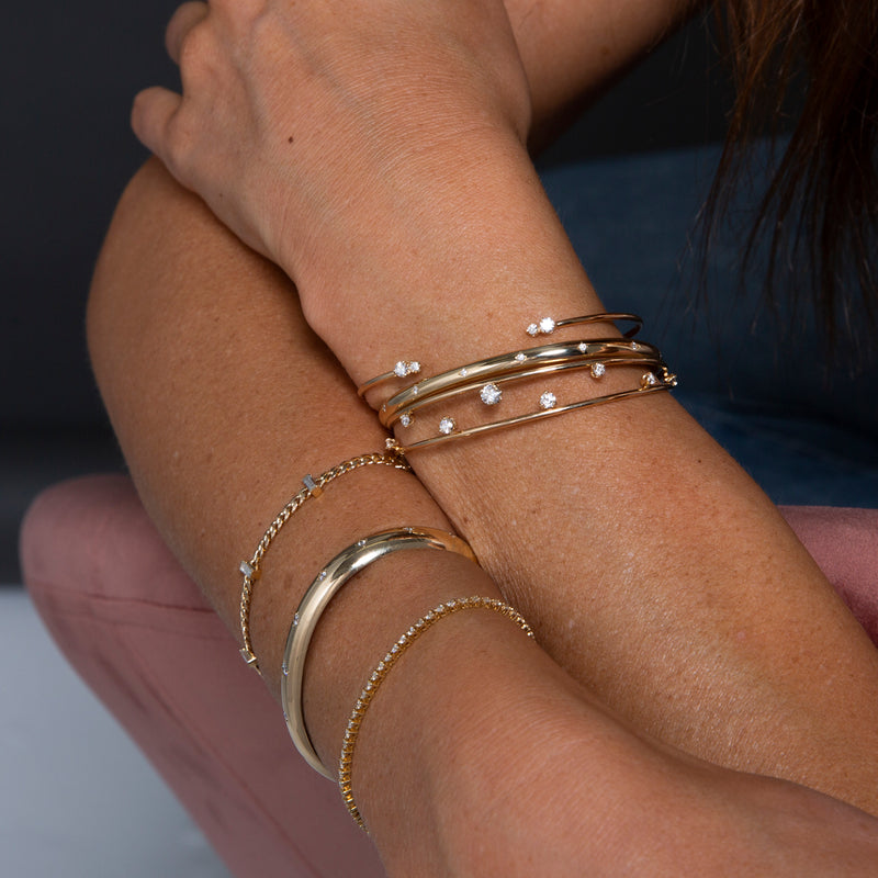 woman's arms resting on each other wearing Zoë Chicco 14kt Gold Prong Diamond Double Band Cuff Bracelet on one wrist