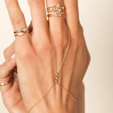 close up of woman's hand wearing a Zoe Chicco 14k Gold 3 Princess Diamond Hand Chain with rings stacked on her fingers