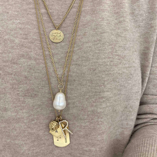 woman wearing a cable chain necklace with a Zoë Chicco 14kt Gold Single Lion Head Charm layered with other charms