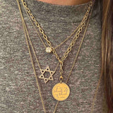 woman in grey t-shirt wearing Zoe Chicco 14karat gold Diamond Bezel Star of David necklace