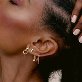 close up of woman's ear wearing Zoë Chicco 14k Gold Chubby Pavé Diamond Door Knocker Huggie Hoop Earrings