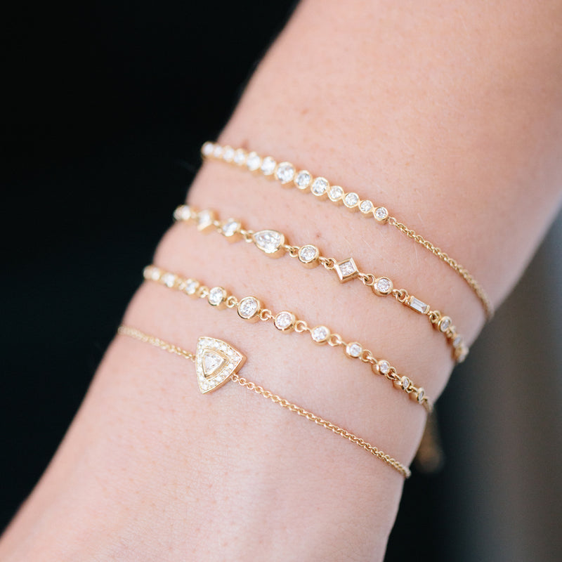 close up of woman's wrist wearing Zoe Chicco 14kt Gold Trillion Diamond Halo Bolo Bracelet