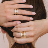 brunette woman with hands behind her head wearing a Zoë Chicco 14k Gold Solid Large Square Oval Link Chain Ring stacked with two aura rings on her middle finger
