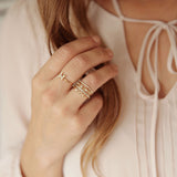 woman's hand wearing Zoë Chicco 14kt Gold Itty Bitty MAMA Ring stacked with other diamond rings