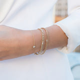 woman in white blazer wearing Zoë Chicco 14kt Gold Floating White Diamond Small Curb Chain Bracelet