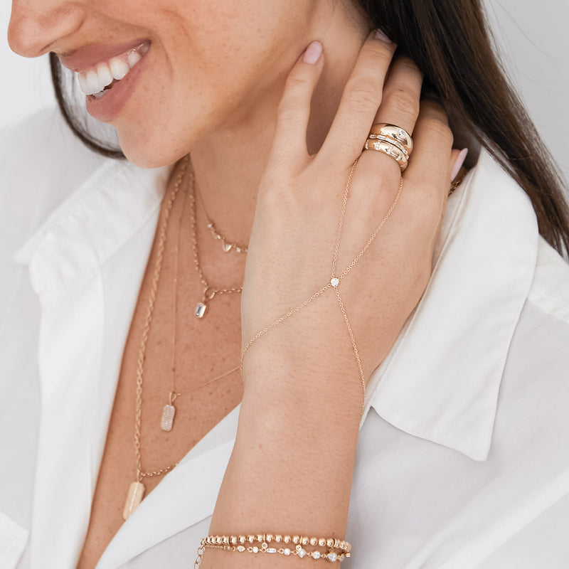woman resting her hand on her neck wearing a Zoë Chicco 14k Gold Floating Diamond Hand Chain