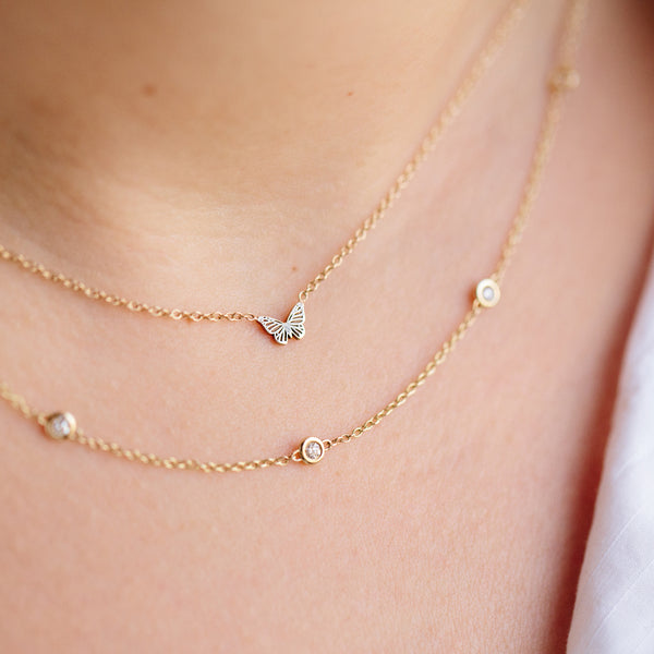 close up of Zoë Chicco 14kt Gold Itty Bitty Butterfly Necklace stacked with a Floating Diamond Chain Necklace