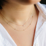 woman in white shirt wearing Zoë Chicco 14kt Gold Itty Bitty Butterfly & Floating Diamond Necklace 