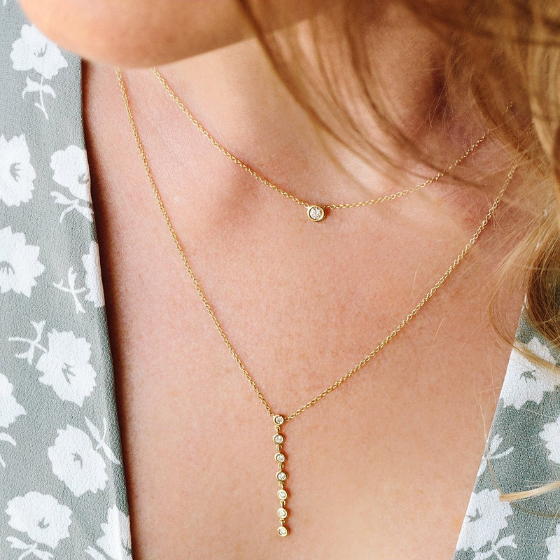 woman wearing Zoë Chicco 14kt Gold 7 Linked Floating Diamonds Y Necklace with a Floating Diamond Necklace