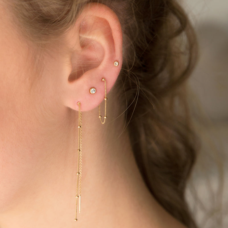 woman's ear wearing a Zoë Chicco 14k Gold Satellite Chain Threader Earring layered with a Satellite Chain Loop Earring