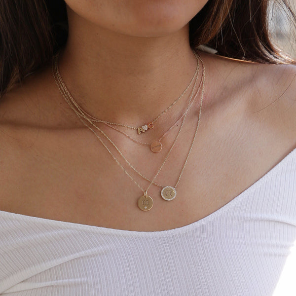 woman in white top wearing Zoë Chicco 14kt Gold Two Letter and Diamond Heart Necklace with A and C pictured