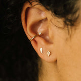 woman's ear wearing a Zoë Chicco 14k Gold Itty Bitty Angel Wing Stud Earring and a Itty Bitty Mushroom Stud Earring