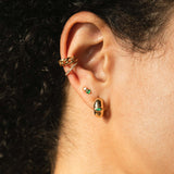 close up of woman's ear wearing Zoe Chicco 14k Gold Medium Curb Chain Ear Cuff layered with a Pave Diamond Thick Ear Cuff, Mixed Emerald and Prong Diamond Stud, and a Marquise Emerald Chubby Huggie Hoop