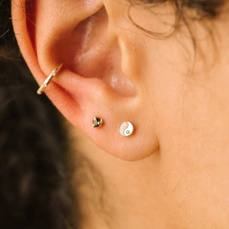 close up of woman's ear wearing a Zoë Chicco 14k Gold Itty Bitty Black & White Diamond Yin Yang Stud Earring