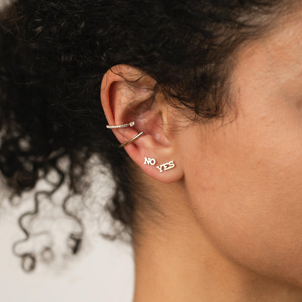 woman's side profile wearing a Zoë Chicco 14k Gold Thick Wire Bar Ear Cuff and Prong Diamond Pave Diamond Ear Cuff with an Itty Bitty No Stud and Yes Stud