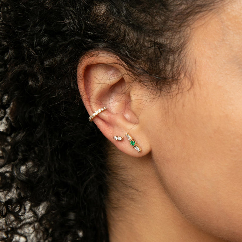 close up of woman's ear wearing Zoë Chicco 14k Gold Emerald & Tapered Baguette Diamonds Stud Earring with a Diamond Bezel Eternity Ear Cuff and Twin Prong Diamond Stud