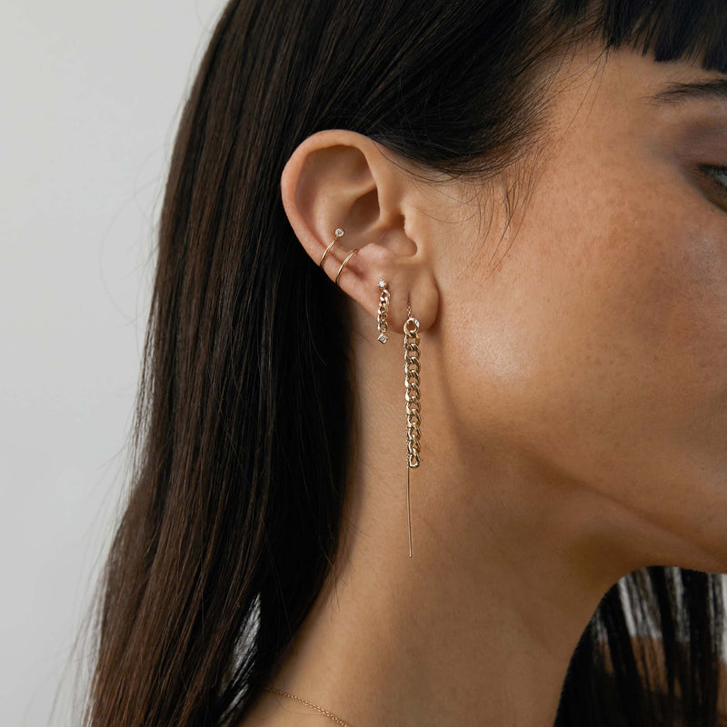 woman's ear wearing a Zoë Chicco 14k Gold Medium Curb Chain Drop Threader Earring layered with a diamond earring and ear cuff