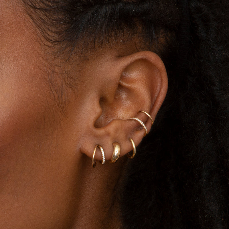 close up of woman's ear wearing Zoe Chicco 14kt Gold Double Wire Pavé Diamond Huggie Hoops