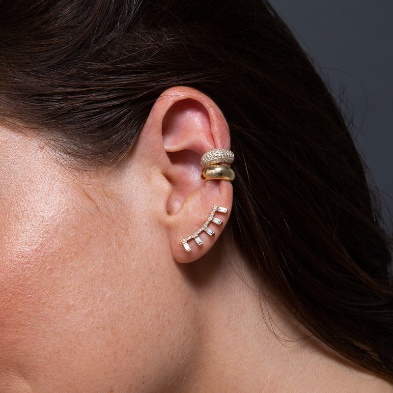 close up of woman's ear on a grey background wearing Zoë Chicco 14k Gold Pavé Diamond Curved Bar Ear Shield with 5 Baguette Diamonds with two Chubby Ear Cuffs