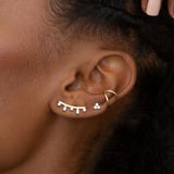 close up of woman's ear wearing Zoë Chicco 14k Gold Baguette & Prong Diamond Curved Bar Ear Shield with a Thick Open Wire Ear cuff and Diamond Trio stud