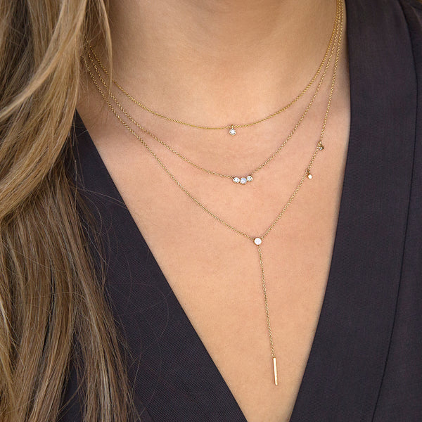 woman in black top wearing Zoë Chicco 14kt Gold 3 Graduated Bezel Set Opal & Diamond Necklace layered with two necklaces