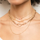 a woman wearing a Zoë Chicco 14k Gold Linked Graduated Pink Ombre Gemstone Necklace layered with multiple other necklaces
