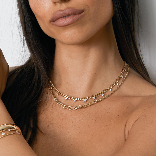 close up of woman wearing a Zoë Chicco 14k Gold Medium Curb Chain Necklace with Graduated Prong Diamonds with a Graduated Rope Chain Necklace