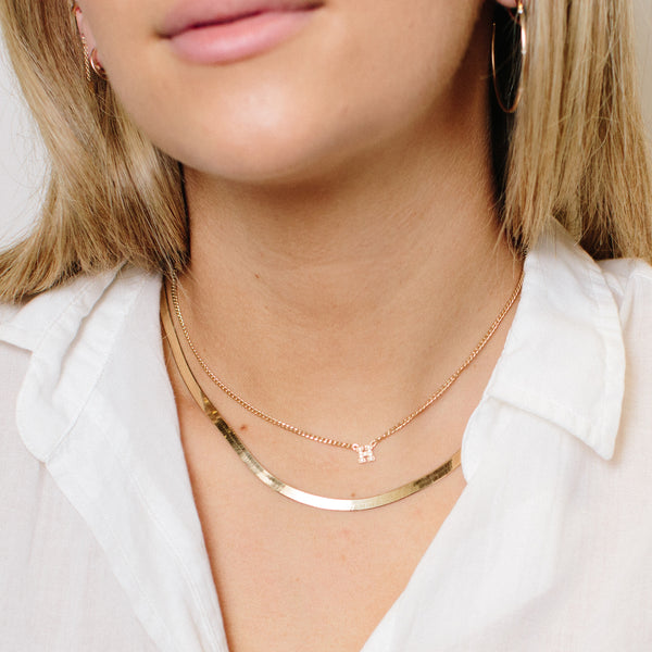 woman wearing Zoë Chicco 14kt Gold Pave Diamond Initial Letter Curb Chain Necklace with a Herringbone Chain