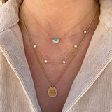 woman in beige top wearing Zoe Chicco 14 karat gold Small Amore Charm Pendant on a curb chain necklace