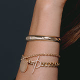 close up of woman's wrist wearing Zoë Chicco 14kt Gold Half Round Star Set Graduated Diamonds Cuff