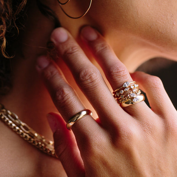 woman resting her hand on her neck wearing a Zoë Chicco 14k Gold Horizontal Pear Shaped Diamond Ring on her index finger