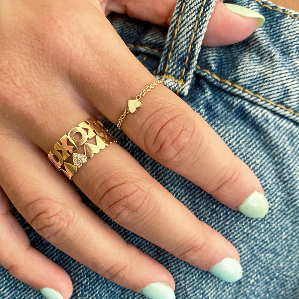 close up of woman resting hand on jeans wearing Zoe Chicco 14kt Gold Itty Bitty Heart Chain Ring
