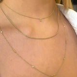 woman's neck wearing Zoe Chicco 14kt Gold Itty Bitty Anchor Chain Necklace layered with a xs curb chain necklace and a Floating Diamond & Tiny Bars Necklace