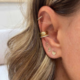 woman's ear wearing Zoe Chicco 14k Gold Itty Bitty Snake Stud Earring with an owl stud, cat with diamond eyes stud, and three gold and diamond ear cuffs
